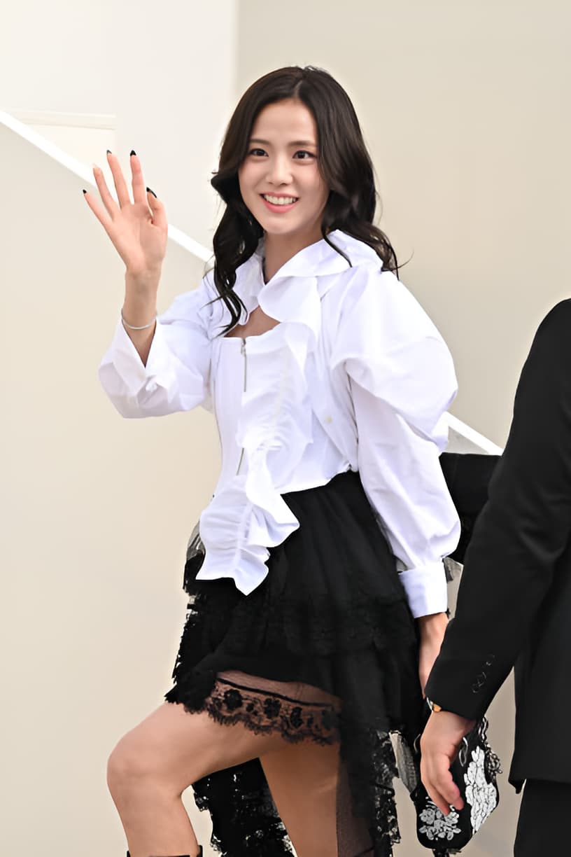 Jisoo at Dior Fall 2025 show in Paris wearing a white corset, puff-sleeve blouse, and lace skirt